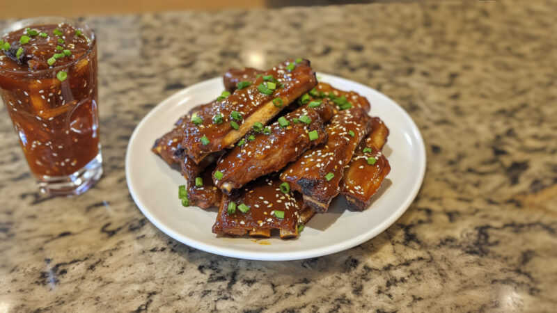 Sweet and Sour Slow Cooker Ribs on a plate with sauce on the side