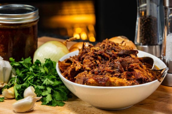 BBQ pulled pork in a bowl surrounded by ingredients