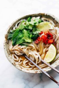 a bowl of turkey pho loaded with vegetables