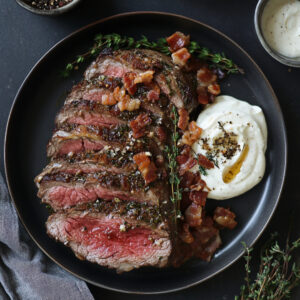 Garlic & Herb Crusted Ribeye Roast with Horseradish Cream and Bacon Shallot Marmalade on a plate