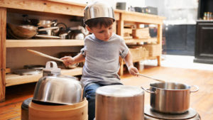 kid playing pan and pots in kitchen