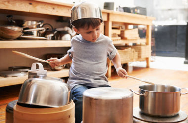 kid playing pan and pots in kitchen