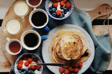 pancake breakfast board with yogurt, berries, and coffee