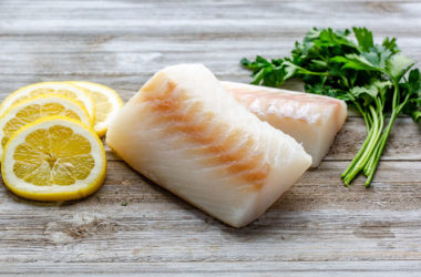Frozen cod filet with lemon rounds and herbs