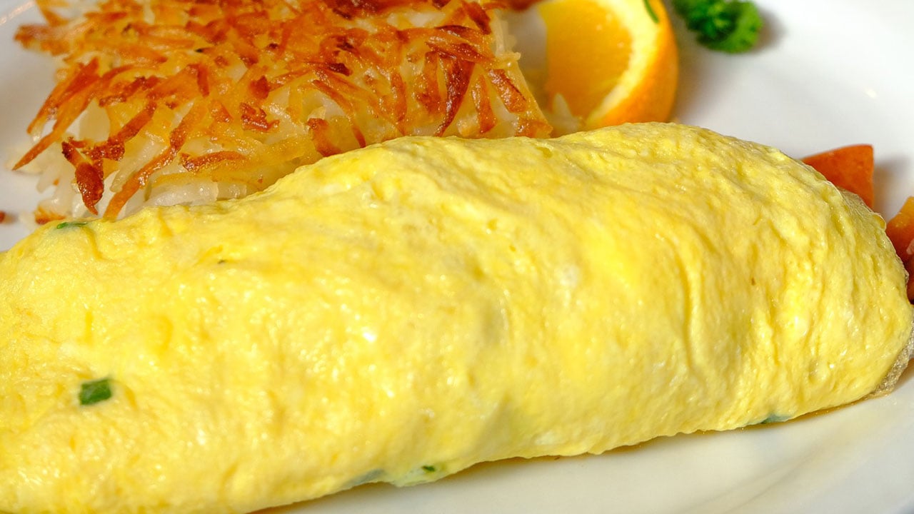 omelet with hash browns and an orange slice