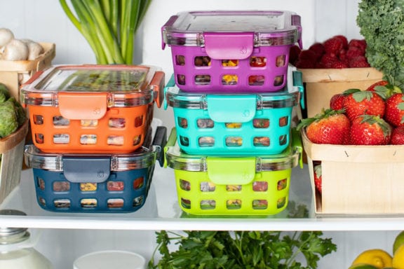 Containers, vegetables, and fruits sitting in a refrigerator