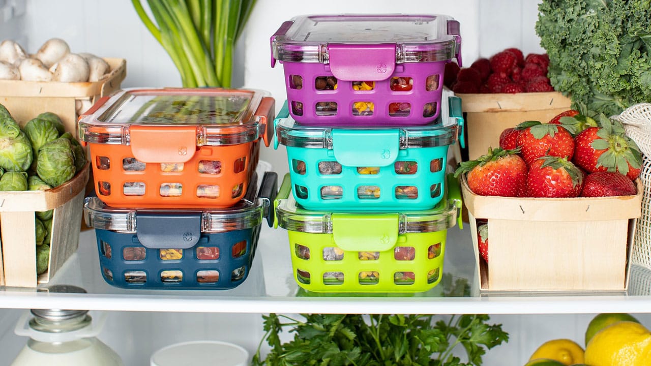 Containers, vegetables, and fruits sitting in a refrigerator