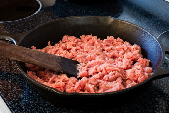 ground turkey cooking in a pan on an electric stove