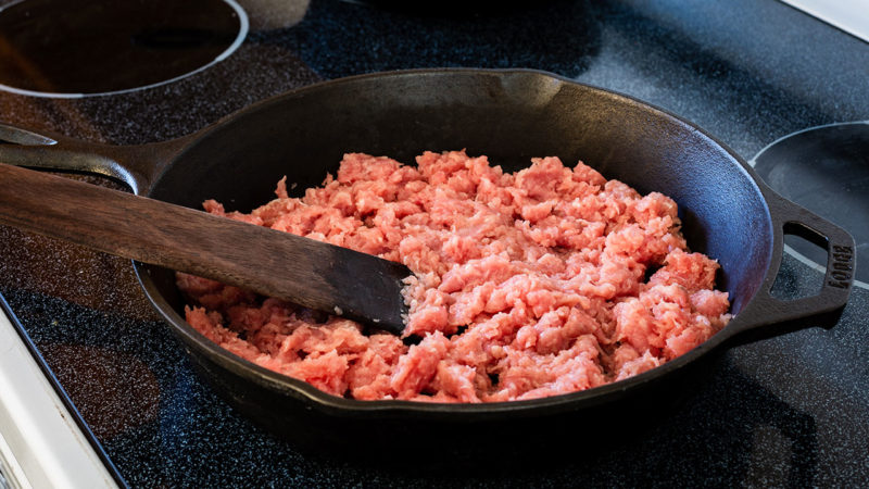 ground turkey cooking in a pan on an electric stove