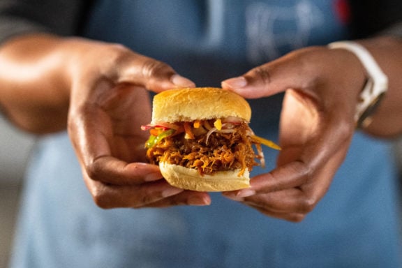 woman holding pulled pork sandwich
