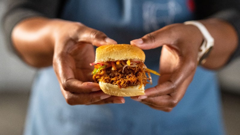 woman holding pulled pork sandwich