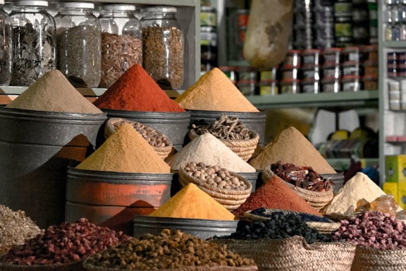 bins and jars filled with spices at a market