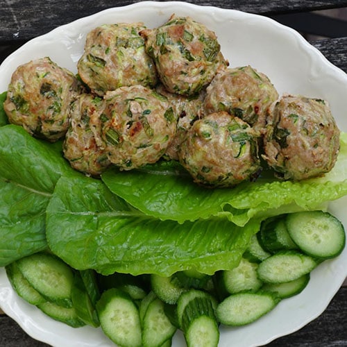 Turkey meatballs and lettuce in a bowl with cucumbers.
