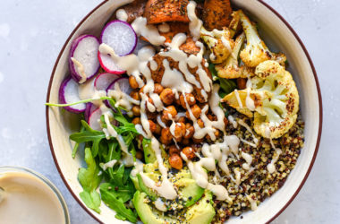 grain bowl with vegetables like radishes, chickpeas, greens, avocado, and cauliflower
