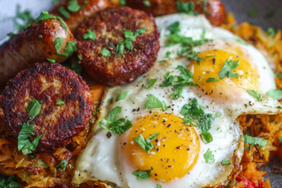 Sausages, Sweet Potato-Shallot Hash Browns and Eggs on a plate