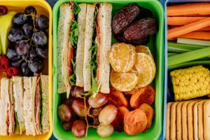 lunchboxes filled with sandwiches and fruit